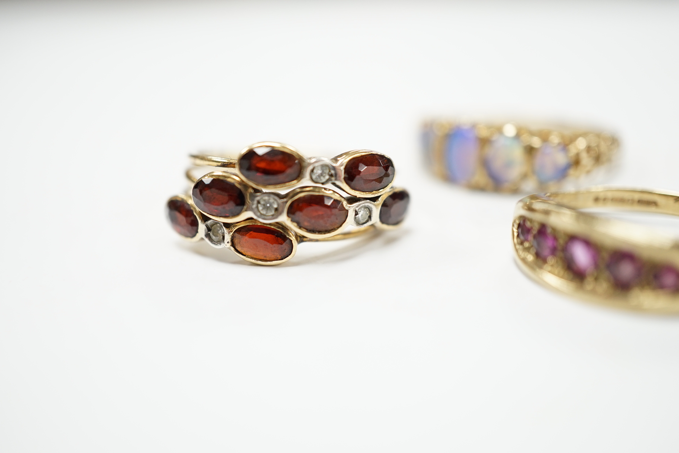 Two recent 9ct gold and gem set rings, including graduated five stone opal half hoop ring, together with a continental and gem set triple shank ring, gross weight 10.5 gram.